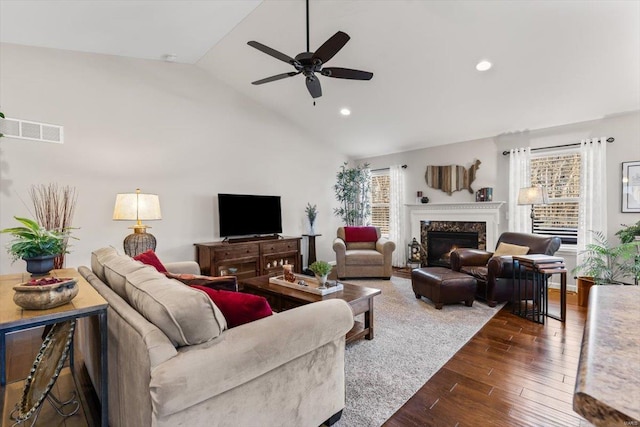 living room featuring lofted ceiling, a fireplace, and ceiling fan