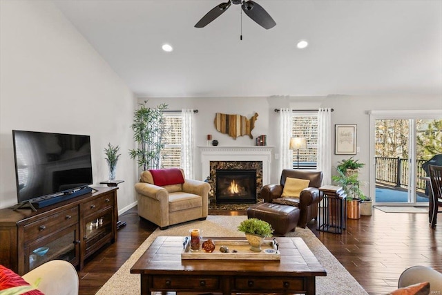 living room with ceiling fan, dark wood-type flooring, and a fireplace