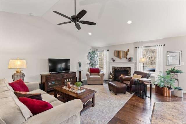 living room featuring ceiling fan, lofted ceiling, a fireplace, and dark hardwood / wood-style flooring