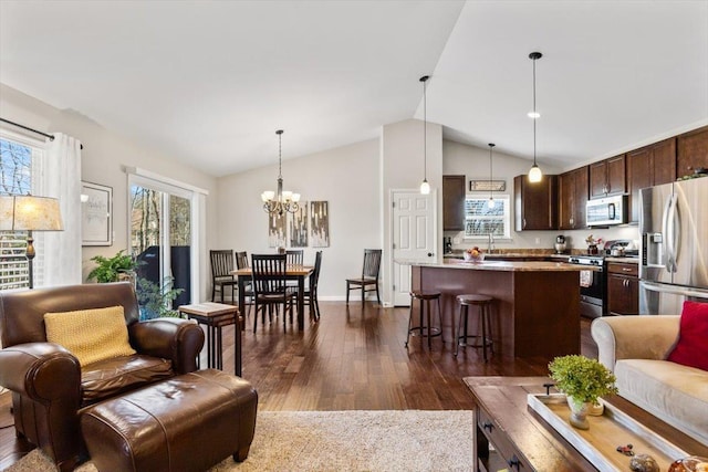 living room with dark hardwood / wood-style flooring, sink, vaulted ceiling, and a chandelier