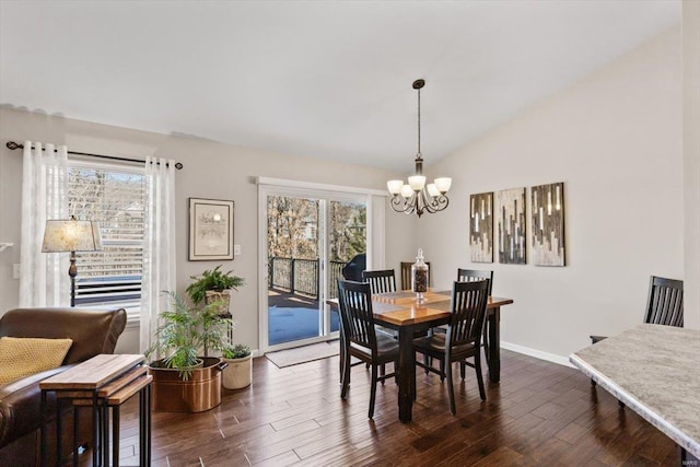 dining room featuring a wealth of natural light, vaulted ceiling, and dark hardwood / wood-style floors