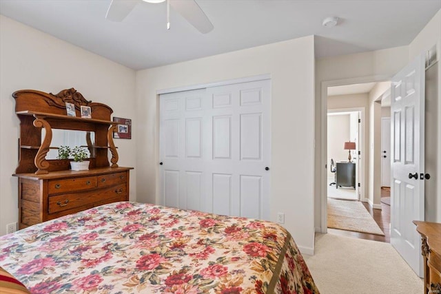 carpeted bedroom featuring ceiling fan and a closet