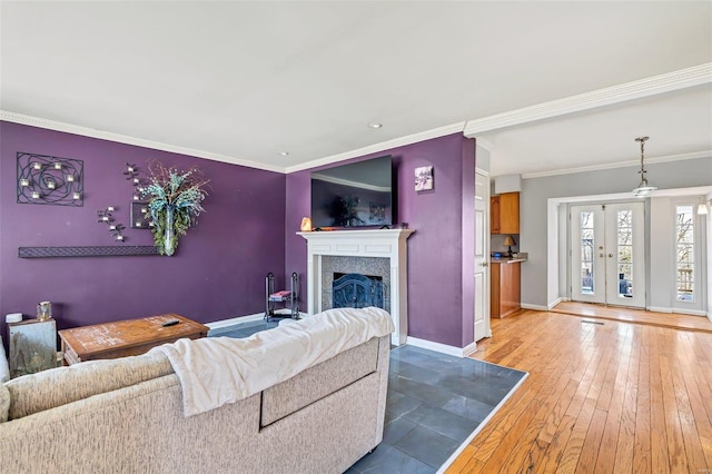 living room featuring light hardwood / wood-style flooring, ornamental molding, and french doors