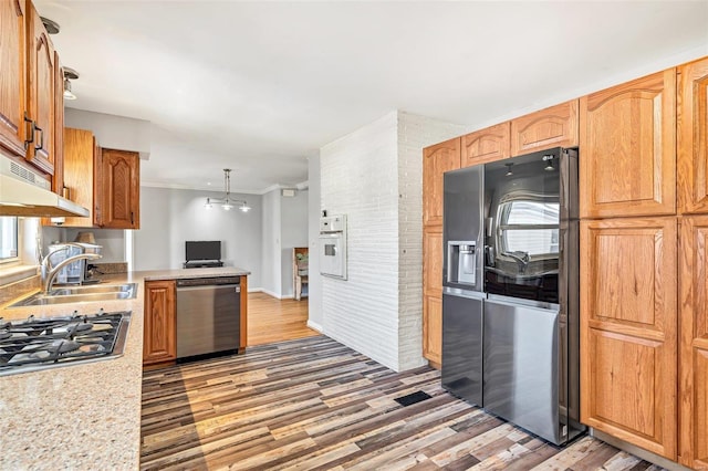 kitchen with decorative light fixtures, sink, ornamental molding, stainless steel appliances, and dark wood-type flooring