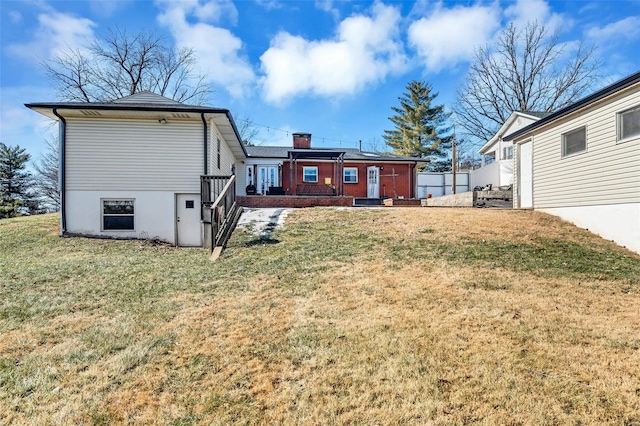 rear view of house featuring a yard