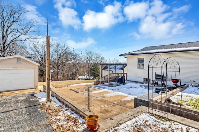 snowy yard featuring a garage and an outdoor structure