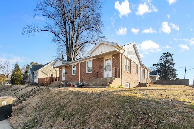 view of front of house featuring fence and brick siding