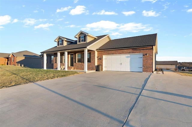 view of front of home with a garage, a front yard, and covered porch