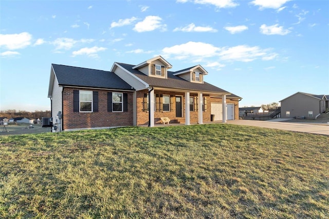 view of front of house with a garage, a front yard, and a porch