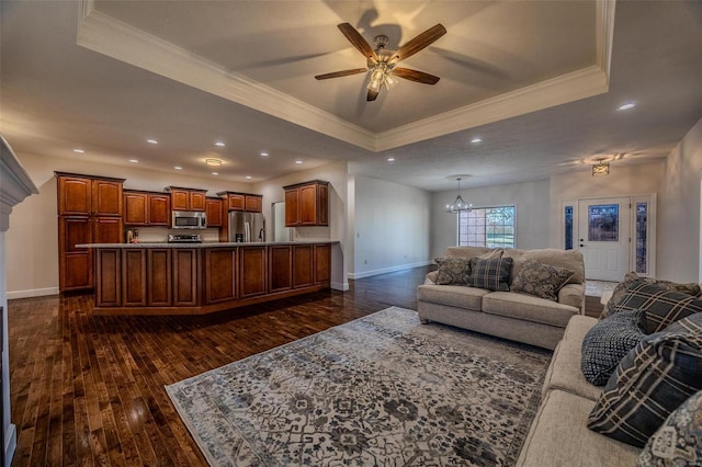 living room with ornamental molding, a tray ceiling, dark hardwood / wood-style flooring, and ceiling fan with notable chandelier