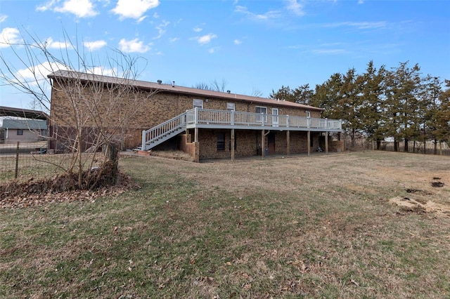 rear view of house featuring a wooden deck and a lawn