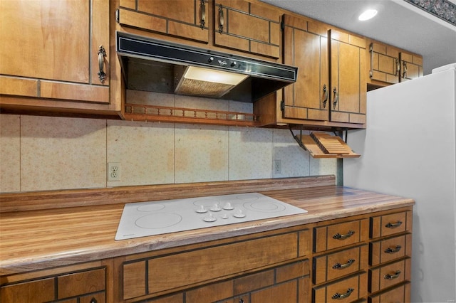 kitchen featuring tasteful backsplash, refrigerator, and white electric stovetop