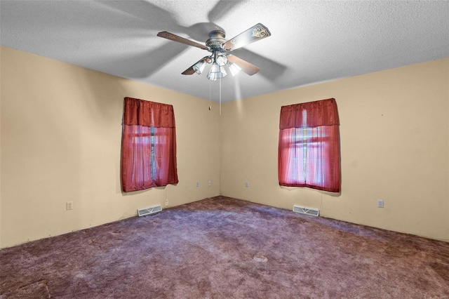 spare room featuring ceiling fan, a textured ceiling, and carpet