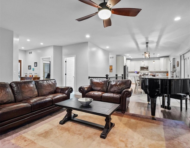 living room with ceiling fan and light wood-type flooring