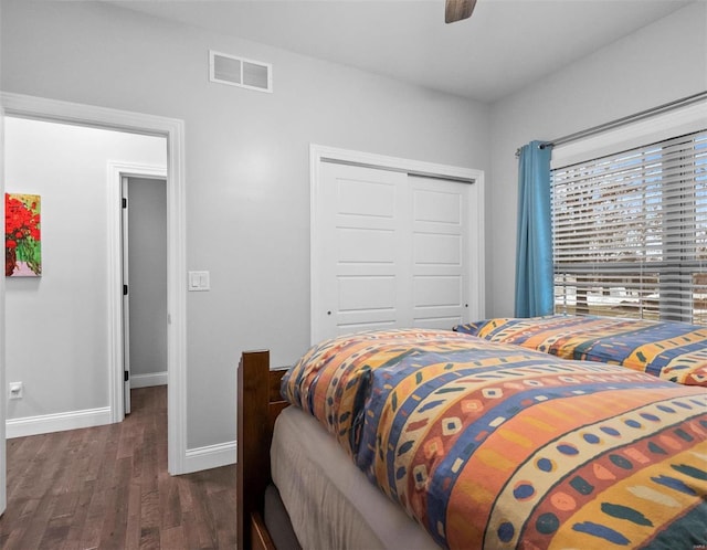 bedroom with dark hardwood / wood-style flooring, a closet, and ceiling fan