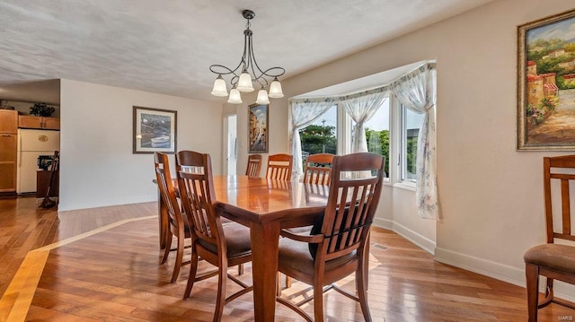 dining area featuring an inviting chandelier and light hardwood / wood-style floors