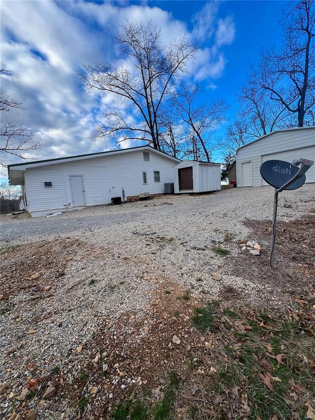 rear view of property featuring a garage and an outdoor structure