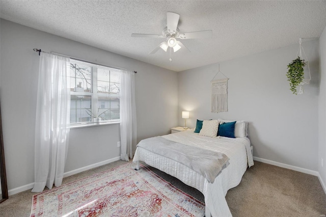 carpeted bedroom with ceiling fan and a textured ceiling