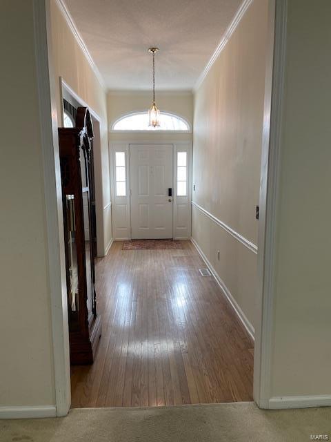 entryway with hardwood / wood-style flooring and ornamental molding