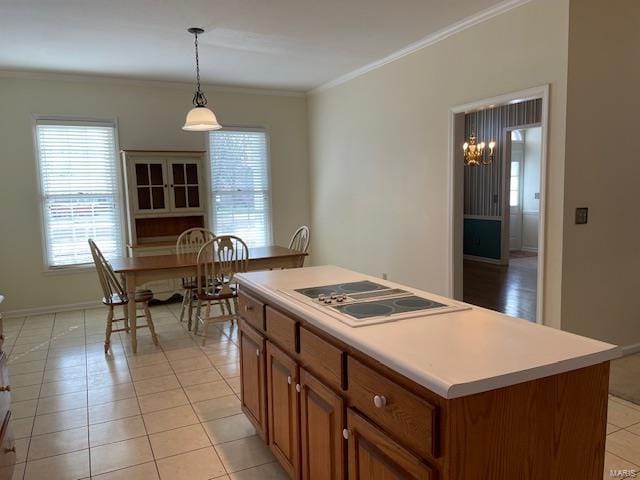 kitchen featuring light tile patterned flooring, crown molding, a center island, white electric stovetop, and pendant lighting