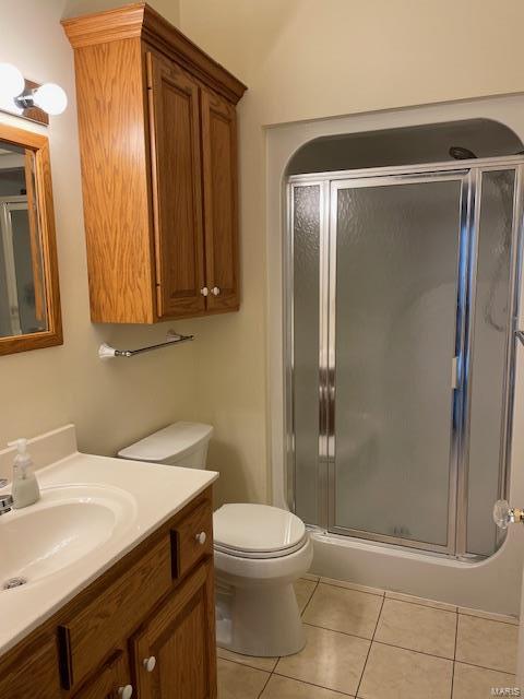 bathroom with vanity, tile patterned flooring, toilet, and walk in shower