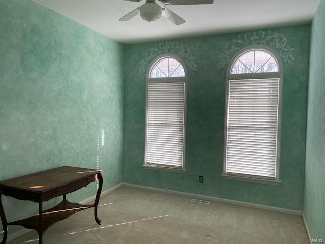 interior space with light colored carpet and ceiling fan