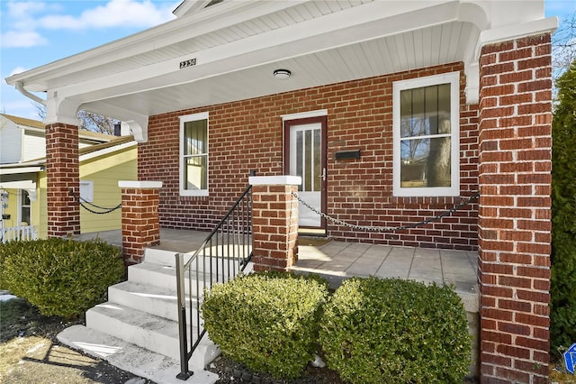 view of exterior entry featuring covered porch