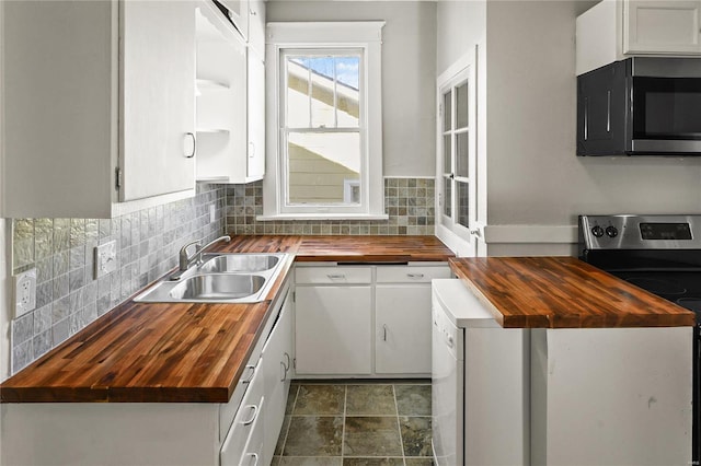 kitchen featuring appliances with stainless steel finishes, butcher block counters, and white cabinets