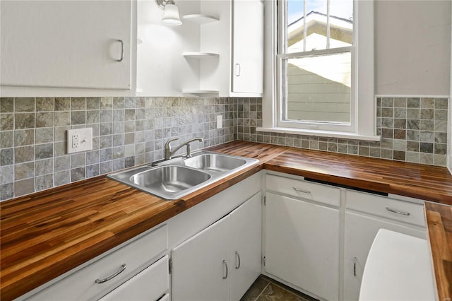 kitchen featuring white cabinetry, sink, and butcher block countertops