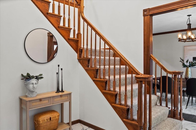 stairs with baseboards, a chandelier, and ornamental molding