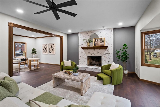 living area with recessed lighting, a premium fireplace, baseboards, and wood finished floors