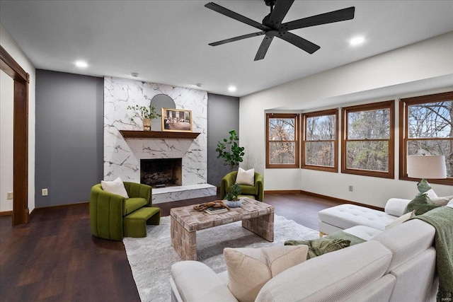 living room featuring a high end fireplace, recessed lighting, dark wood-type flooring, and baseboards