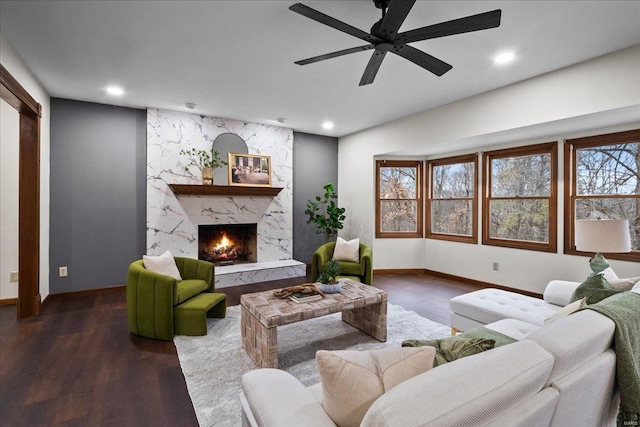 living room with recessed lighting, baseboards, dark wood-style floors, and a high end fireplace