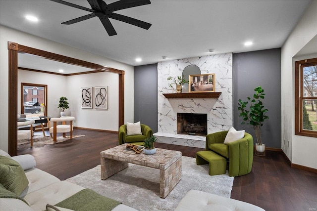 living room featuring recessed lighting, baseboards, wood finished floors, and a fireplace