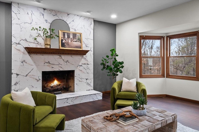 living area with a high end fireplace, recessed lighting, baseboards, and wood finished floors