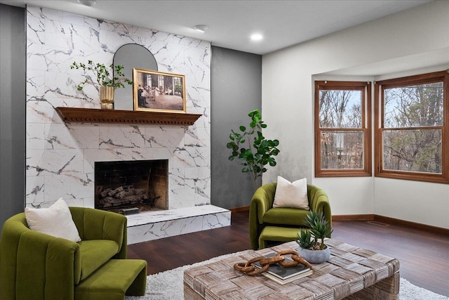 living room featuring recessed lighting, a premium fireplace, baseboards, and wood finished floors