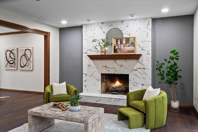 living room with recessed lighting, baseboards, wood finished floors, and a high end fireplace