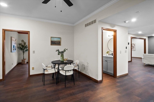 dining space featuring dark wood finished floors, visible vents, baseboards, and ornamental molding