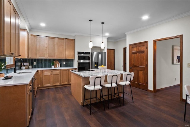 kitchen with a sink, backsplash, a center island, appliances with stainless steel finishes, and dark wood-style flooring