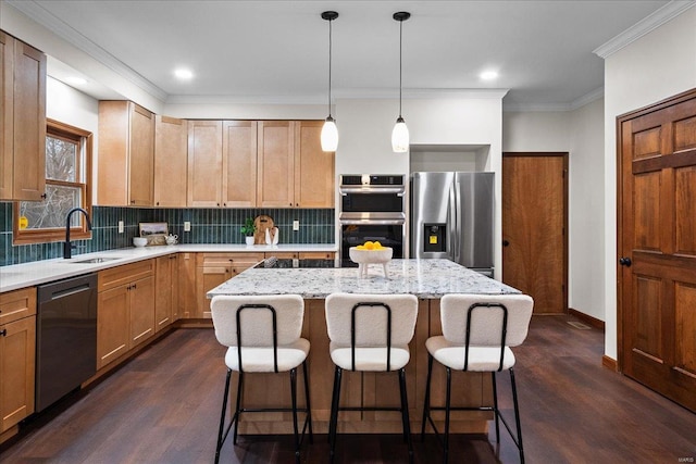 kitchen featuring backsplash, a center island, crown molding, appliances with stainless steel finishes, and a sink