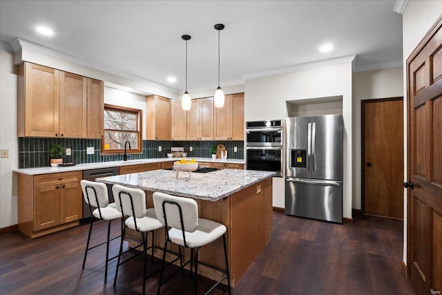 kitchen featuring a sink, a center island, dark wood-style flooring, and stainless steel appliances