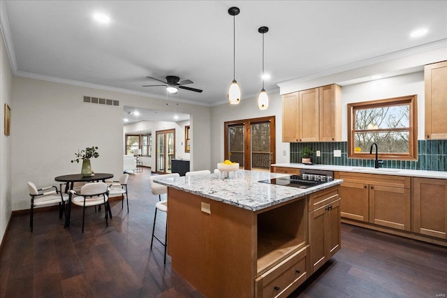 kitchen with visible vents, a sink, a kitchen island, dark wood-style floors, and black electric cooktop