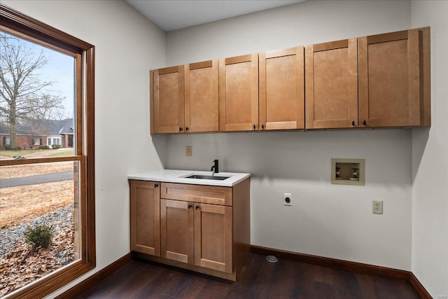 clothes washing area featuring a sink, dark wood finished floors, cabinet space, hookup for an electric dryer, and hookup for a washing machine