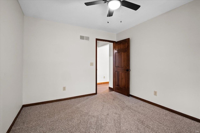 empty room featuring visible vents, carpet flooring, baseboards, and ceiling fan