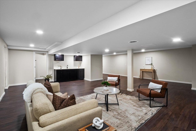 living room featuring dark wood finished floors, visible vents, wet bar, and baseboards