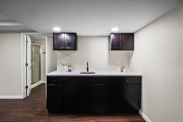 kitchen featuring light countertops, dark wood-style floors, baseboards, and a sink