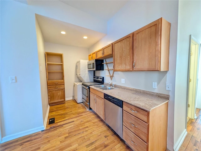 kitchen featuring stainless steel appliances, sink, and light wood-type flooring