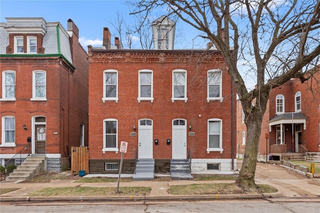 townhome / multi-family property with entry steps and brick siding