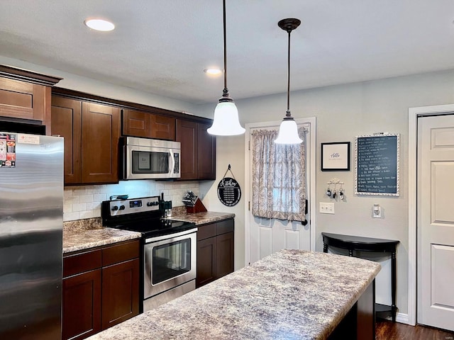 kitchen with tasteful backsplash, stainless steel appliances, decorative light fixtures, and dark brown cabinets