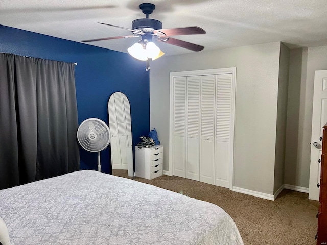 bedroom with ceiling fan, carpet floors, a textured ceiling, and two closets